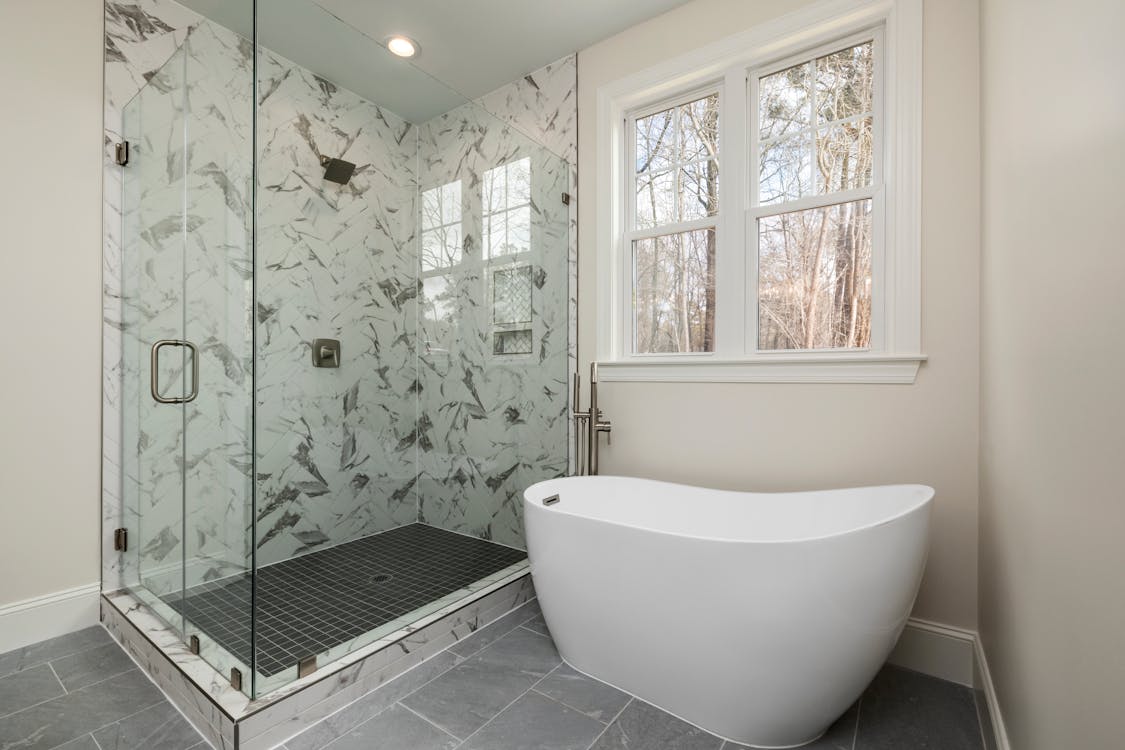 A sleek white bathtub in a clean, modern bathroom setting.